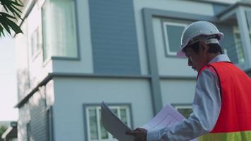 concepto de construcción. El contratista está inspeccionando la casa con referencia a las normas de construcción. los ingenieros están haciendo los controles finales antes de entregarlos a los clientes. video