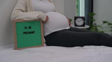 Pregnant women gently pat stomach with hands. video