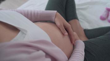 mulheres grávidas acariciam suavemente a barriga com as mãos.