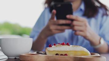 A reviewer's hand using a mobile phone to take pictures of food at a restaurant table.Take photo to write a review of the restaurant to share on the internet. video