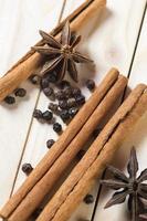 Spices and herbs. Food and cuisine ingredients. Cinnamon sticks, anise stars and black peppercorns on a wooden background. photo