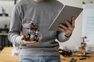 man with tablet learning make robot close up