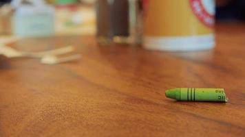 Green color pastel crayon rolls on brown wooden table video