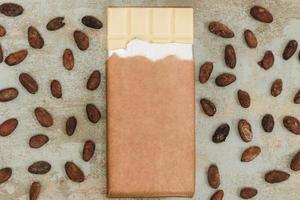 Granos de cacao esparcidos con barra de chocolate blanco grunge antecedentes