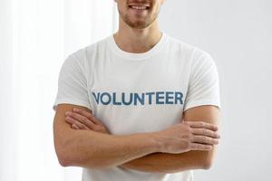 voluntario masculino sonriente posando con los brazos cruzados foto