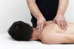 Hombre recibiendo masaje de espalda por fisioterapeuta