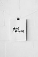 good morning text paper attach with bulldog paper clip white wall photo