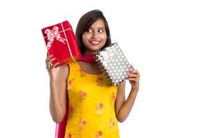 Portrait of young happy smiling Indian Girl holding gift boxes on a white background. photo