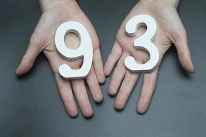 To female hands the figure of ninety-three. photo
