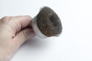 Hand holding a metal brush on white background. photo