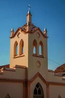pequeña fachada de la iglesia y campanario con luz solar en un lado y sombra en el otro, al atardecer en sao manuel. un lindo pueblito en el campo del estado de sao paulo. sudeste de brasil. foto