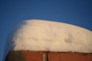 paisajes nevados y primeros planos de nieve en rayos de sol. hierba y objetos en la nieve. foto