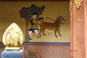 mural con el hombre y el tigre en el monasterio rinpun dzong en paro, bhután, asia foto