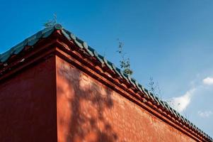 In a temple in fine weather, the sun cast some shadows on the red walls photo