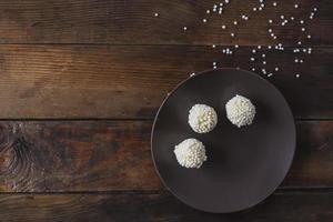 dulces hechos a mano en forma de bolas con partículas crujientes blancas. deliciosos dulces caseros foto