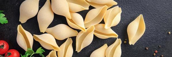 Conchiglioni raw pasta royal seashells food background photo