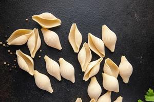 Conchiglioni raw pasta royal seashells food background photo