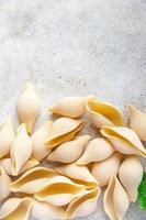 Conchiglioni raw pasta royal seashells food background photo