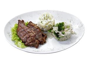 bistec de ternera con patatas y arroz de fondo blanco aislado foto