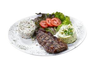 Beef steak with potatoes and rice in isolated white background photo