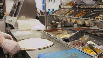 Chef preparing a Pizza Bianca with olive spread, cheese and pieces of garlic and mushrooms video