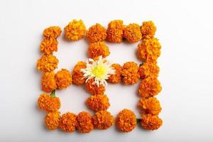 diseño de rangoli de flores de caléndula con lámparas de aceite para el festival de diwali. foto