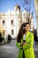 mujer joven escuchando música con smartphone en la calle