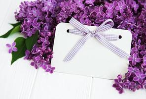 Lilac flowers with greeting card on a table photo