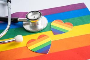 estetoscopio negro con el corazón en el fondo de la bandera del arco iris, símbolo del mes del orgullo lgbt, celebración anual social en junio, símbolo de gay, lesbiana, bisexual, transgénero, derechos humanos y paz.