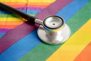 Black stethoscope on rainbow flag background, symbol of LGBT pride month  celebrate annual in June social, symbol of gay, lesbian, bisexual, transgender, human rights and peace. photo