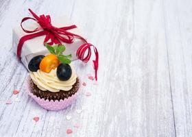 Cupcakes with fresh berries and gift box photo