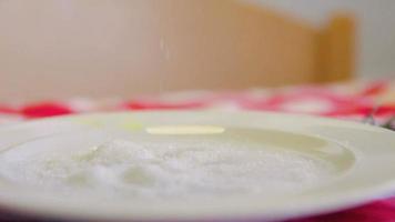 cinemagrafia de derramar açúcar em um prato branco
