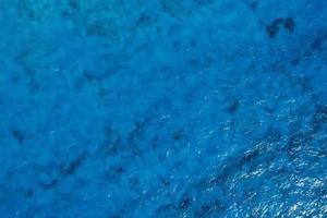 textura de mar azul turquesa con olas y espuma. foto