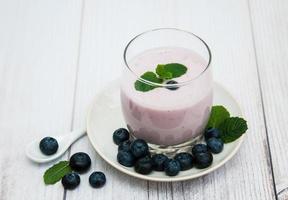 Glass with blueberry yogurt on a table photo