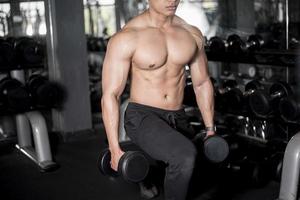 cerrar hombre musculoso es ejercicio en el gimnasio foto