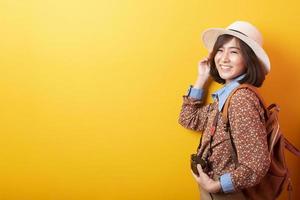 feliz joven turista asiática sobre fondo amarillo