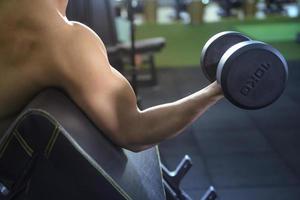 El fisicoculturista de fitness muscular está entrenando con pesas en el gimnasio foto