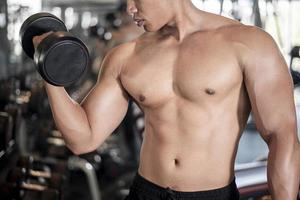 Close up muscular man is exercise in fitness gym