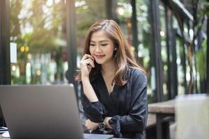 una mujer asiática inteligente está trabajando con una computadora portátil foto