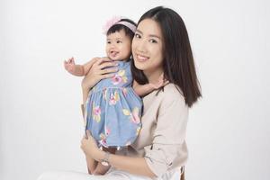 la madre asiática y la adorable niña son felices con antecedentes blancos
