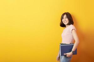 bella estudiante universitaria asiática feliz con antecedentes amarillos