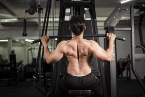 Bodybuilder man with big muscular  back in the gym photo