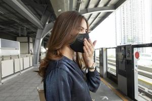 hermosa mujer con máscara antipolvo protege la contaminación del aire y pm 2.5 en la ciudad de la calle foto