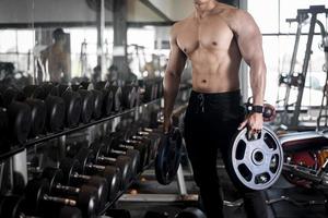 Close up muscular man is exercise in fitness gym photo