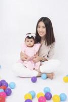 Asian mother and adorable baby girl are  happy on white background photo