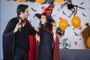 happy couple of love  in costumes and makeup on a celebration of Halloween photo