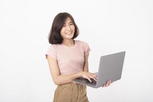 Cute Asian teen woman is working with computer on white background photo