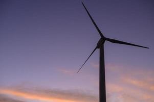 a background of wind turbines  at sunset.
