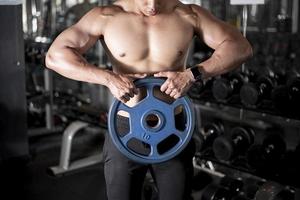 Close up muscular man is exercise in fitness gym photo