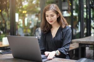 Smart Asian female is working with laptop computer